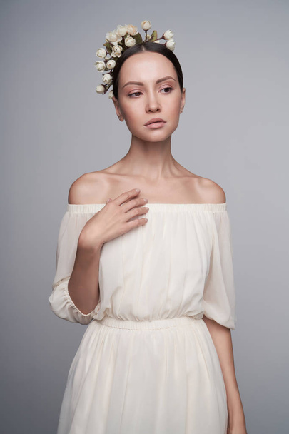 Woman in white greek dress with flowers on her head - Фото, изображение