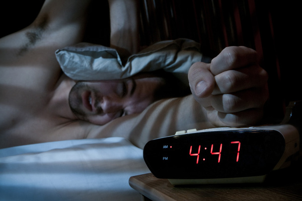 Unhappy man smashing the alarm clock. - Foto, imagen