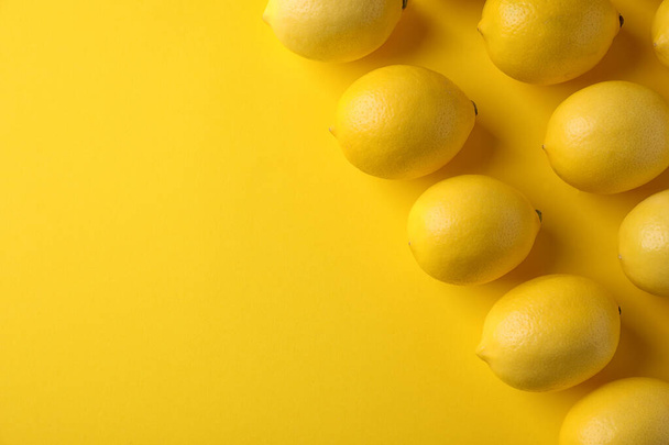 Ripe lemon fruits on yellow background, flat lay. Space for text - Foto, immagini