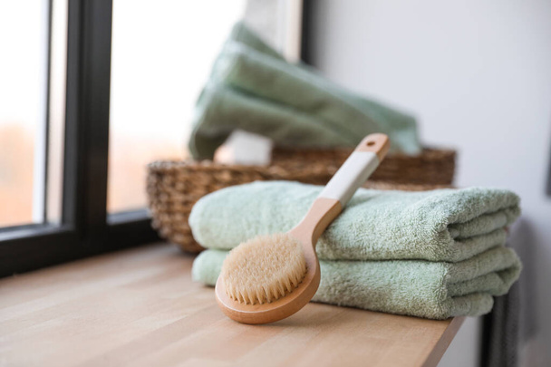 Clean soft towels and shower brush on windowsill in bathroom - Foto, Imagem