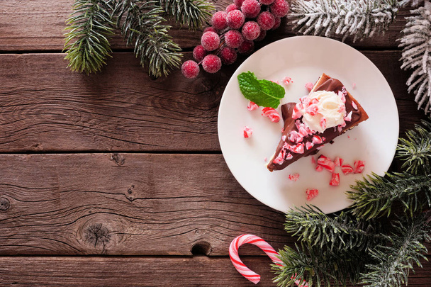 Christmas candy cane chocolate cheesecake. Top view corner border over a dark wood background with copy space. - Fotografie, Obrázek