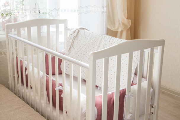 Baby bed crib with white and Burgundy color pillows with laces - Photo, Image
