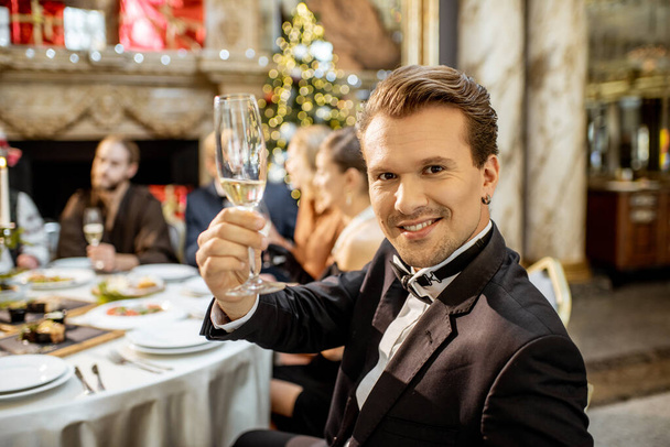 Mann mit Freunden bei einem festlichen Abendessen an Silvester - Foto, Bild