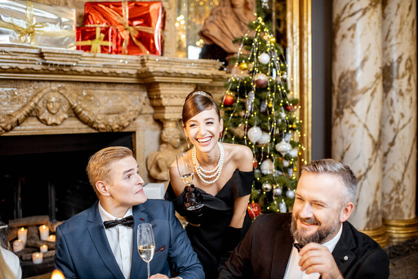 Портрет элегантно одетых людей, празднующих Новый год в помещении
 - Фото, изображение