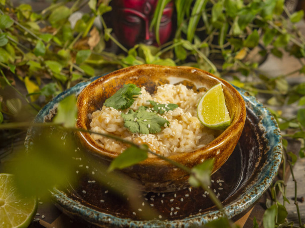 Delicious rice with shrimp and herbs and a slice of lime on craft dishes - Foto, imagen