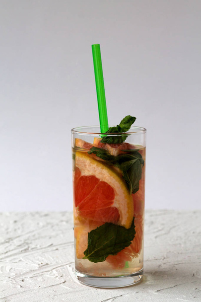 red grapefruit cocktail with green mint on white background. Detox citrus cocktail. healthy lifestyle. - Foto, Imagem