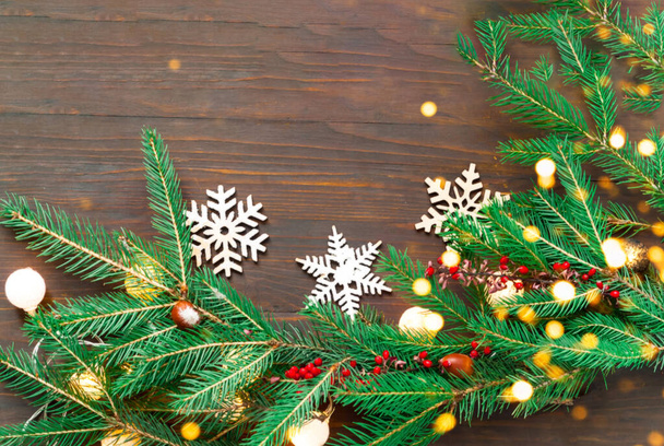 Vánoční věnce smrkových větví na dřevěném pozadí. Novoroční prázdninový koncept. Rozmazaný efekt. Horní pohled, kopírovací prostor - Fotografie, Obrázek