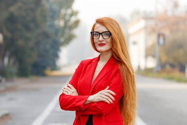 赤いビジネススーツを着た赤い髪の美しい女の子バス - 写真・画像