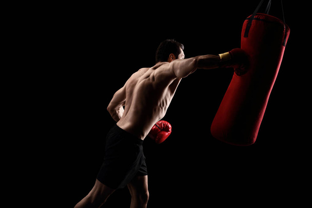 Strong boxer hitting a punching bag - 写真・画像