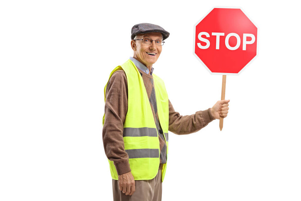Homme âgé portant un gilet de sécurité et tenant un panneau stop
 - Photo, image