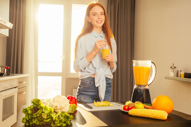 beautuful redhaired ginger woman useing eco tubes for drink smoothie at home,sunset sun light background - Fotó, kép