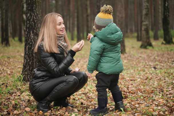 caucasian young mother and little child having fun in autumn Park, walking - Photo, Image