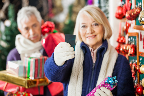 Woman Holding Credit Card At Christmas Store - Фото, изображение