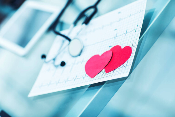 health concept: two red paper heart on the electrocardiogram, the cardiologist. - Photo, image