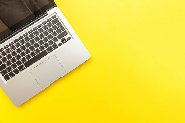 Tastatur-Laptop-Computer isoliert auf gelbem Tischhintergrund. Fortschritte bei moderner Informationstechnologie und Software - Foto, Bild