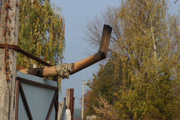 cheminée brune en fer carbonisé au-dessus d'une clôture grise dans la rue
 - Photo, image