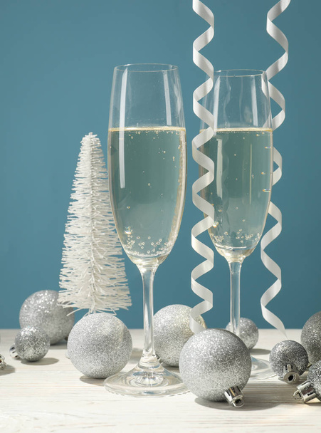 Champagne glasses and baubles against blue background, space for - Photo, image