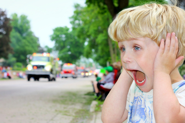dítě pokrývající uši na hlasité parade - Fotografie, Obrázek