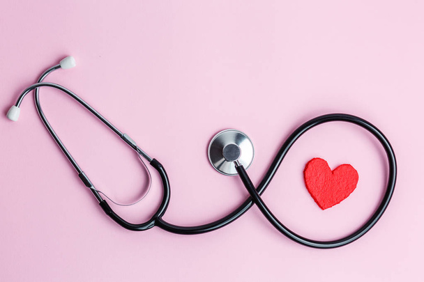 Stethoscoop en hart op een roze achtergrond - Foto, afbeelding