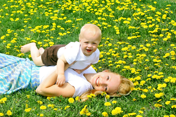 Mother and Baby Laying in Dandelions - Photo, Image