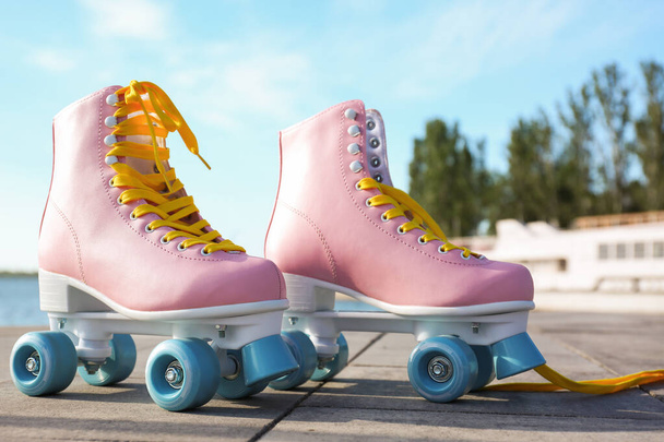 Stylish vintage roller skates on city embankment - Zdjęcie, obraz