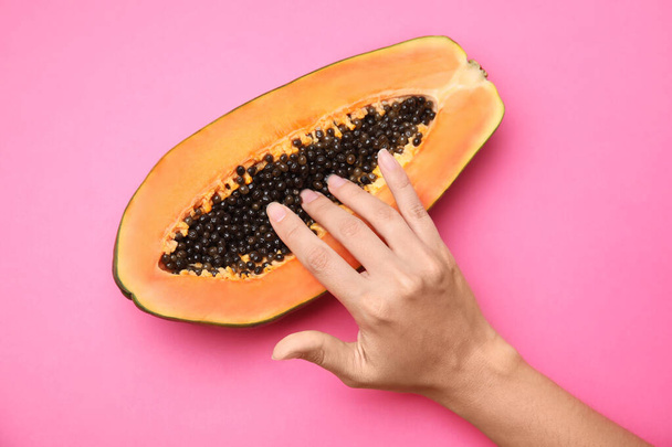 Young woman touching half of papaya on pink background, top view. Sex concept - Foto, Imagem