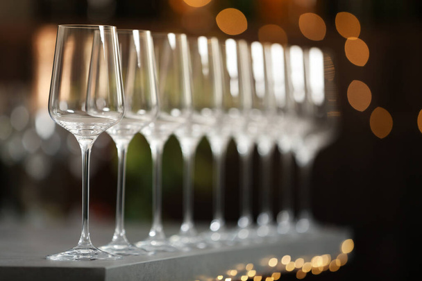Set of empty wine glasses on grey table against blurred background - Φωτογραφία, εικόνα