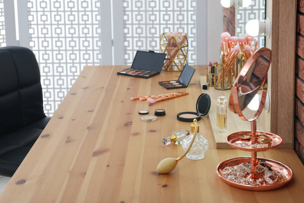 Cosmetici e pennelli sul tavolo da trucco in sala trucco
 - Foto, immagini