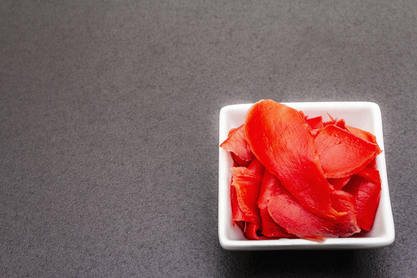 Pickled sushi ginger slices in white bowl on stone background - Foto, immagini
