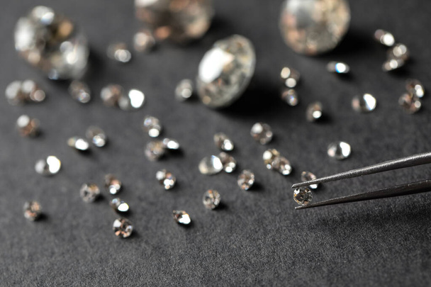 Tweezers with beautiful gemstone over grey table - 写真・画像