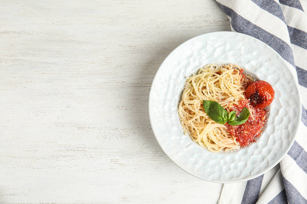 Tasty pasta and napkin on white wooden table, flat lay. Space for text - Foto, afbeelding