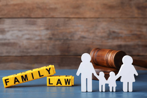 Figure in shape of people, cubes with words Family Law and gavel on blue wooden table - Photo, image