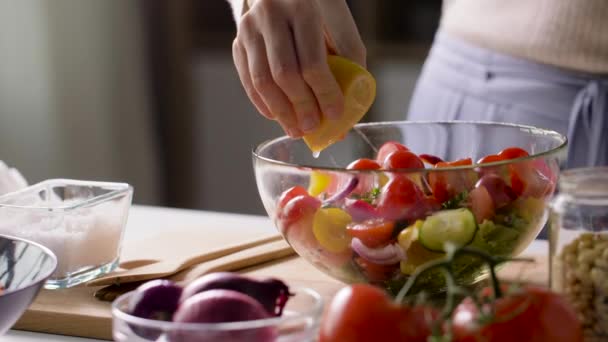 woman cooking vegetable salad with lemon at home - Video