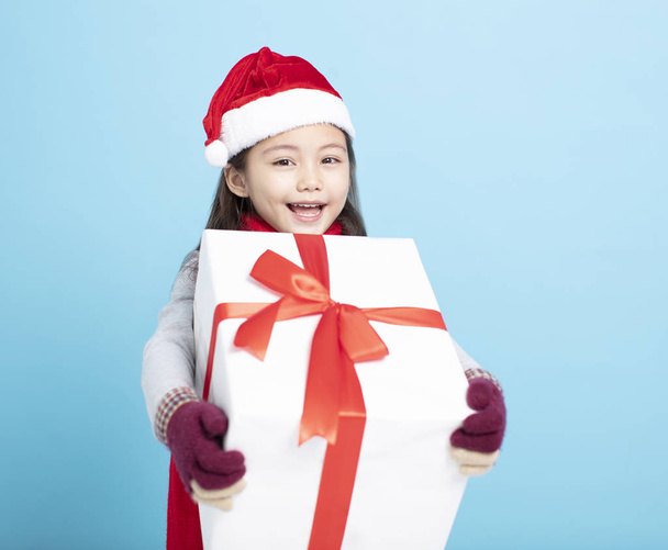 boldog kislány a Mikulás kalap és a kezében ajándék doboz - Fotó, kép