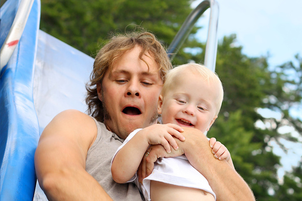 Father and Baby Sliding at Playground - 写真・画像