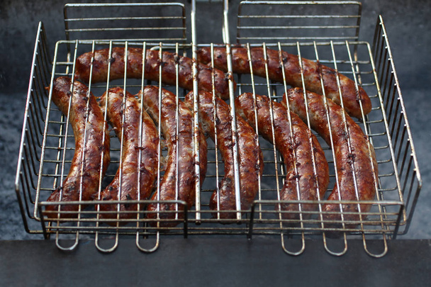 Grillrácsok közé préselt húsos kolbász, grillsütőn sütve - Fotó, kép