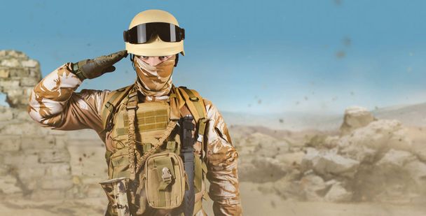 Soldado en uniforme de pie en el desierto saludando
. - Foto, Imagen