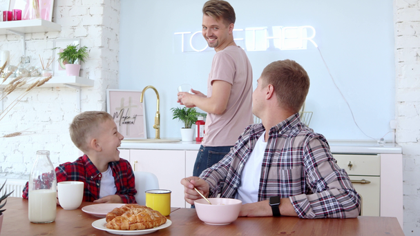 Happy gay rodina dva otcové a syn mají snídani v kuchyni. - Záběry, video