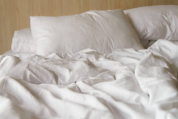 manta blanca arrugada con almohadas suaves en la cama cómoda por la mañana. arruinado después de las noches de sueño
 - Foto, Imagen