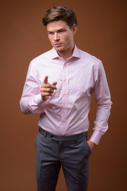 Studio shot of young handsome businessman with pink shirt - Foto, Imagem