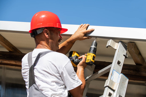 The professional worker works on installation of a roof  - Foto, Imagem