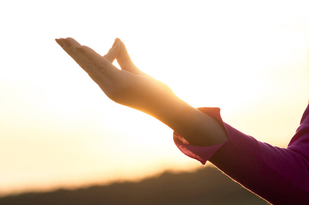 Luz de fondo de una mujer ejercitando yoga al atardecer con una ba de calidez
 - Foto, Imagen