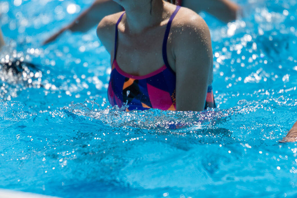 Женщины, занимающиеся водной аэробикой на открытом воздухе в бассейне
 - Фото, изображение