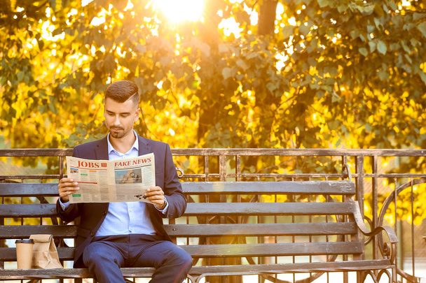 Portrait of handsome businessman reading newspaper outdoors - Foto, Imagen