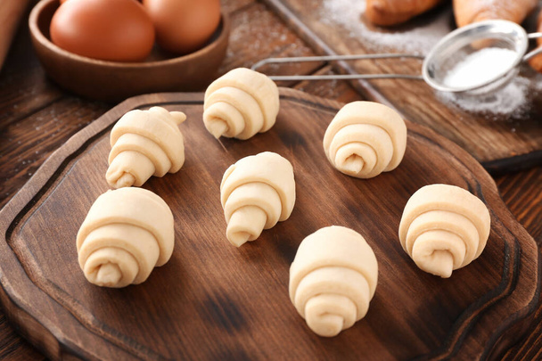 Raw croissants on wooden board - Foto, imagen