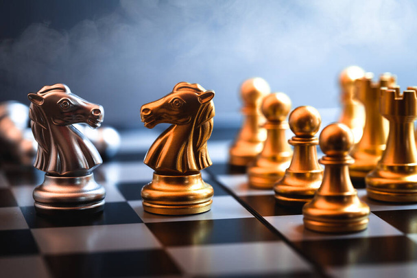 Σκάκι άλογο που αντιμετωπίζουν μαζί αντιπροσωπεύουν τη διαπραγμάτευση ενός αντιπάλου ή εχθρός των επιχειρήσεων σε ένα εμπορικό παιχνίδι πολέμου. - Φωτογραφία, εικόνα