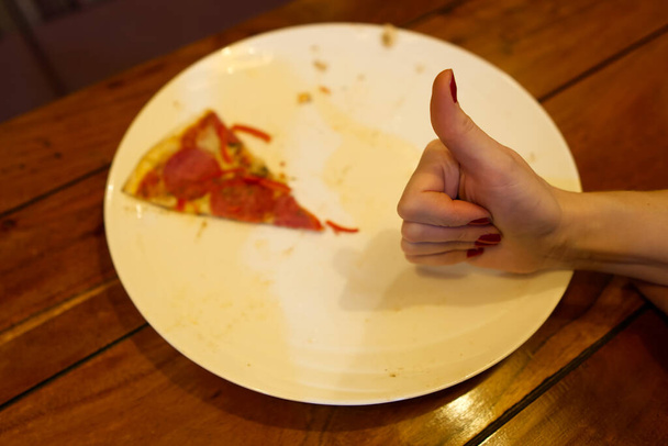 Co za pyszna pizza, był ostatni kawałek pepperoni na białym talerzu. - Zdjęcie, obraz