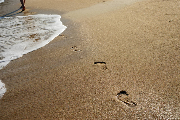 Strandgolf en voetstappen op het strand - Foto, afbeelding