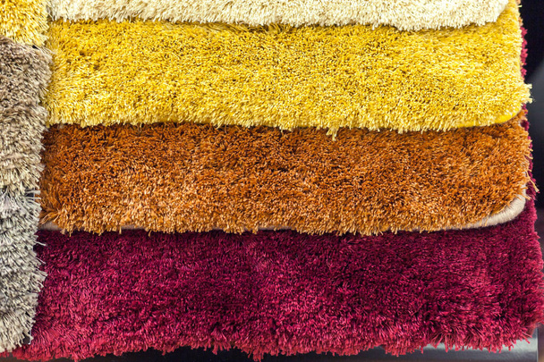 зразки різнокольорових килимів на полицях
 - Фото, зображення