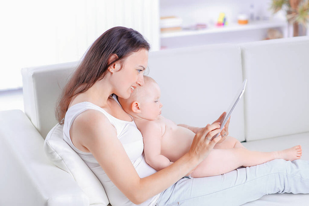 mother and baby are looking to play and read tablet computer - Foto, immagini